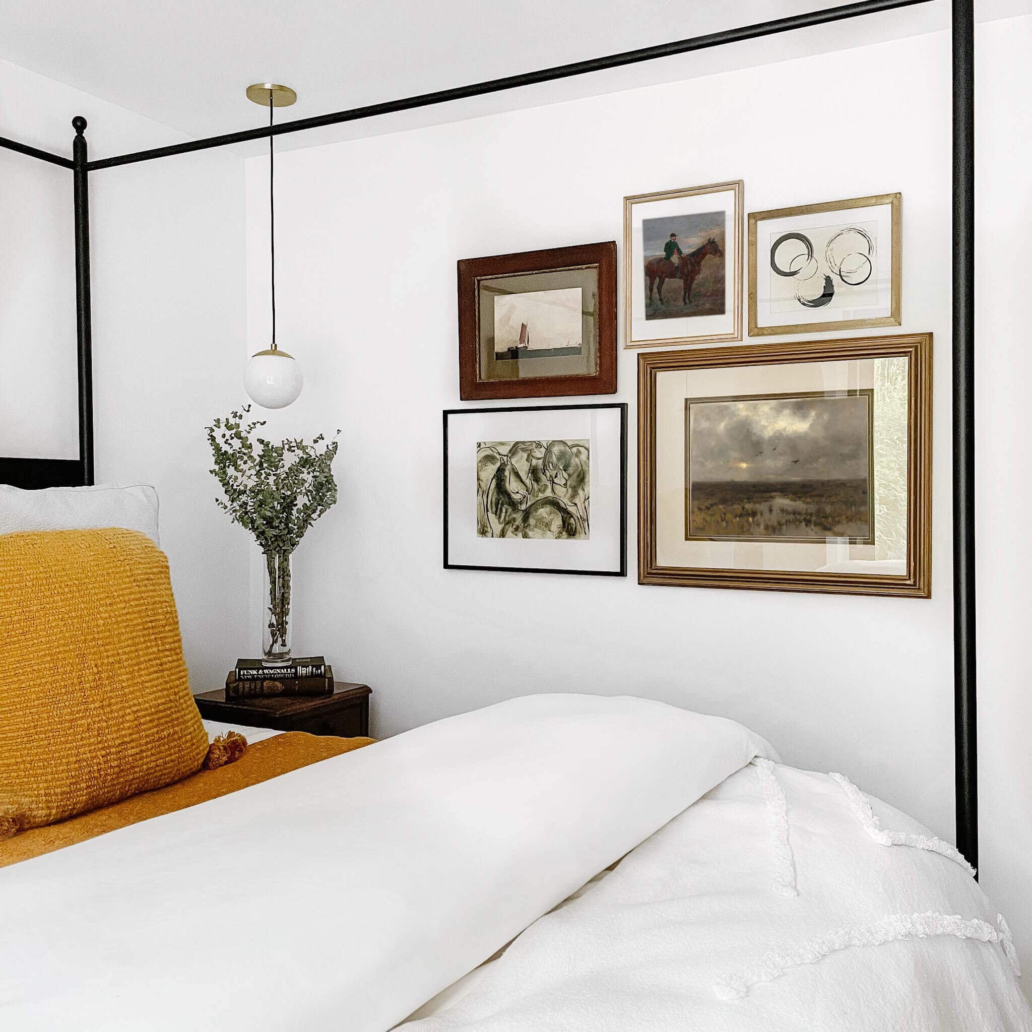 Gallery wall next to a bed.