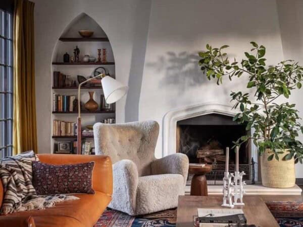 Orange sofa in a room with a white chair and white walls.