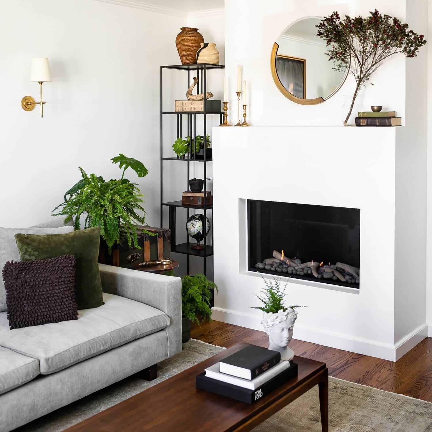 Round mirror above a gas fireplace.