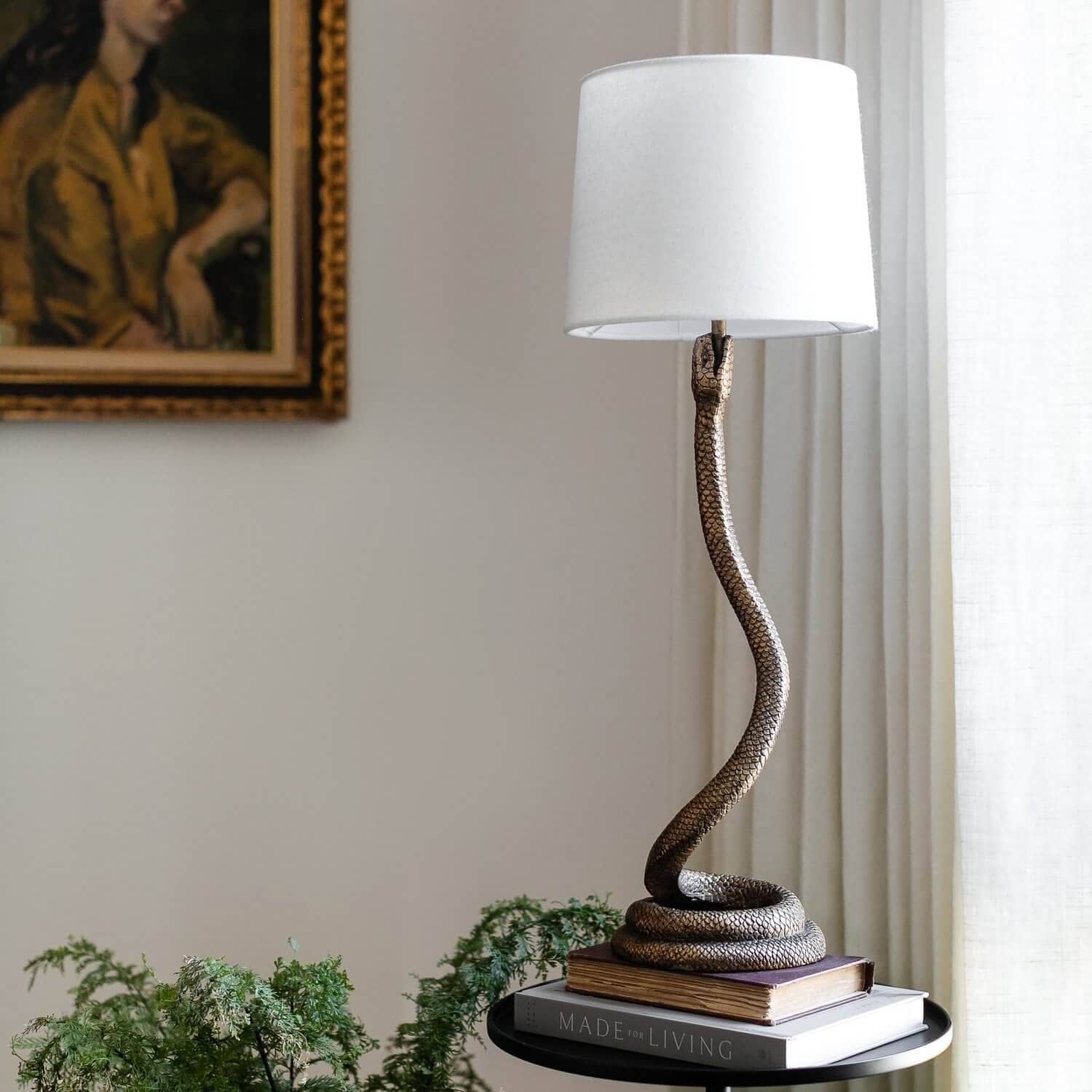 Snake table lamp on a stack of books.
