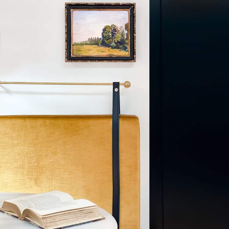 Framed landscape above a banquette.
