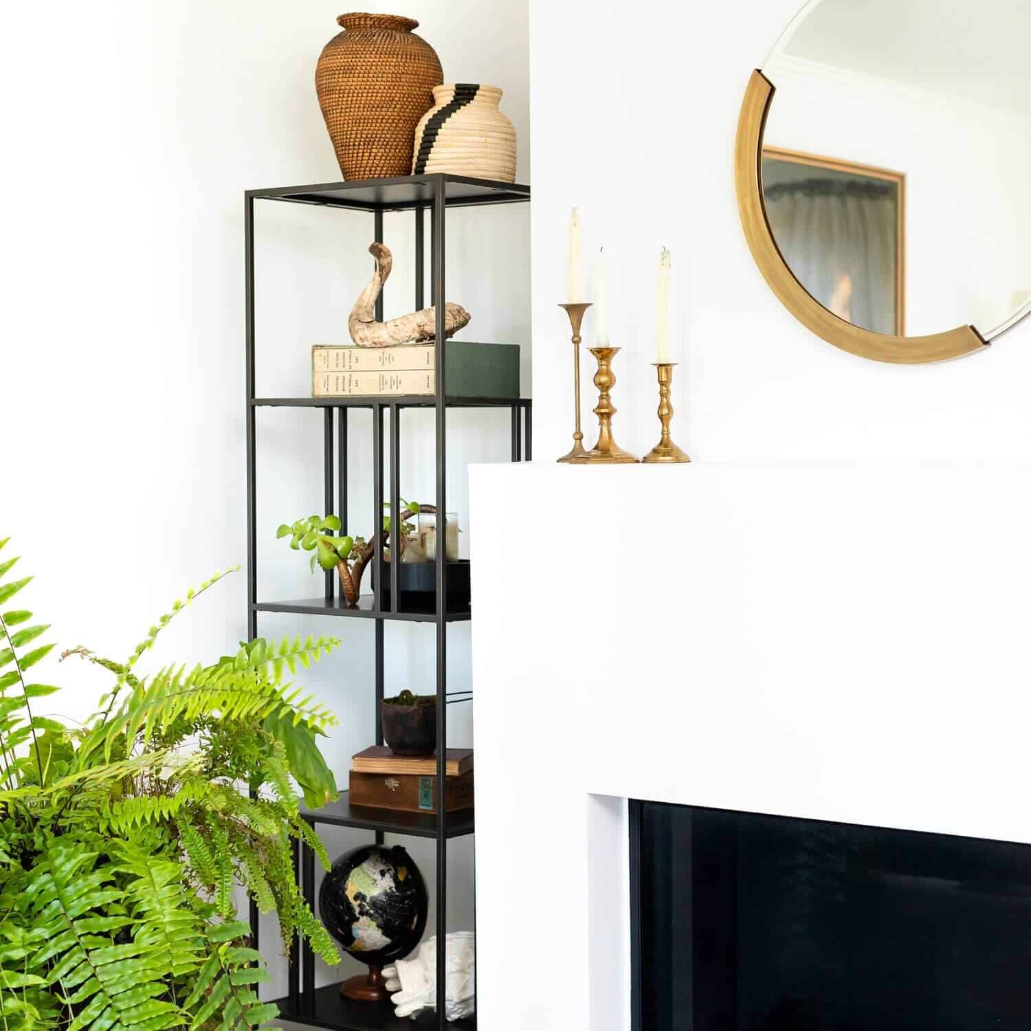 Round, partially-framed mirror over a mantle.