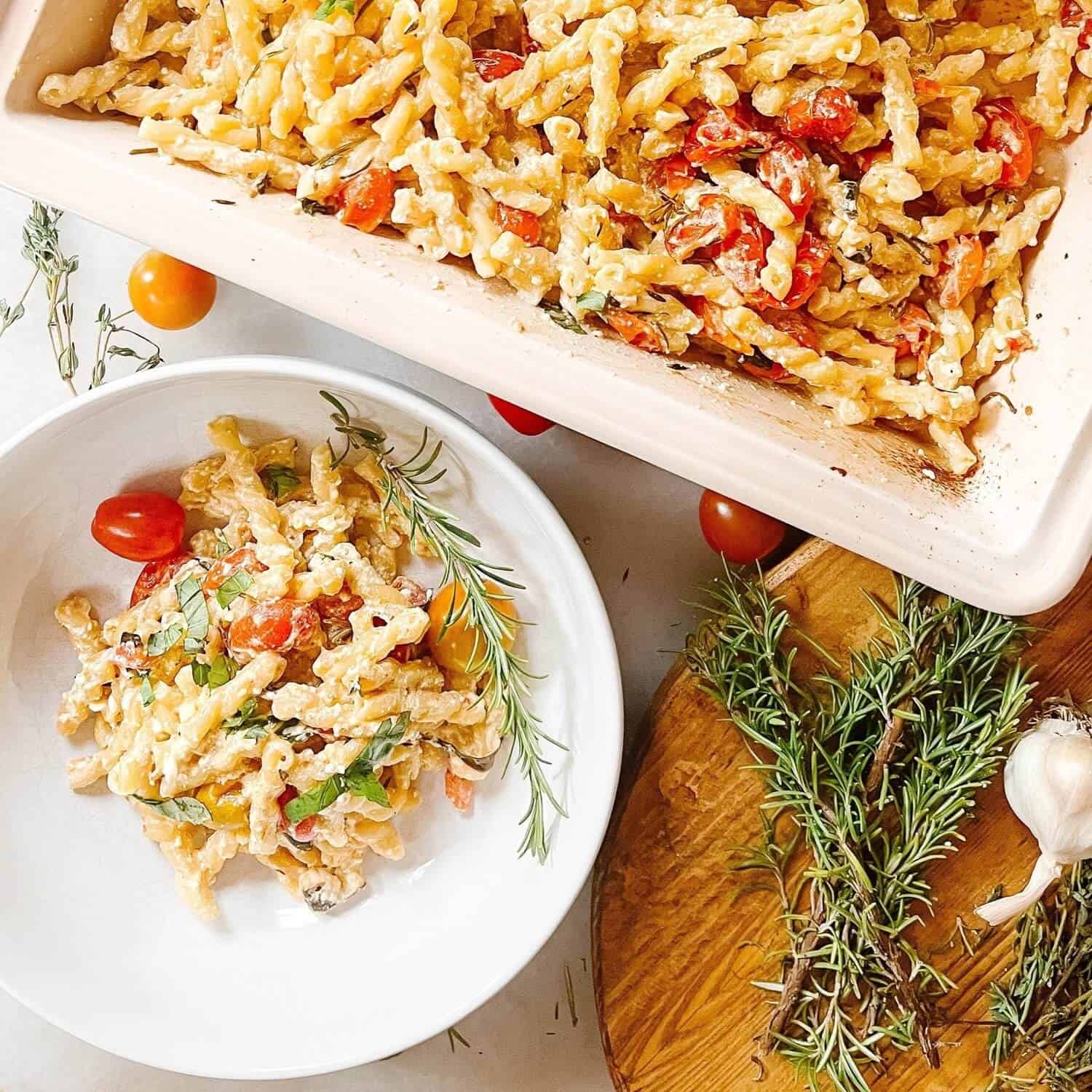 Baked feta pasta on a plate and in a dish.
