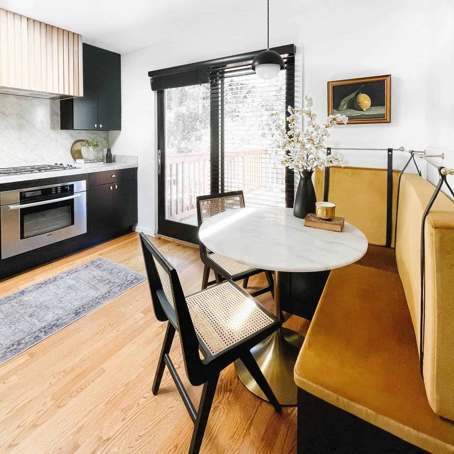 Kitchen with a white table and golden cushioned benches.