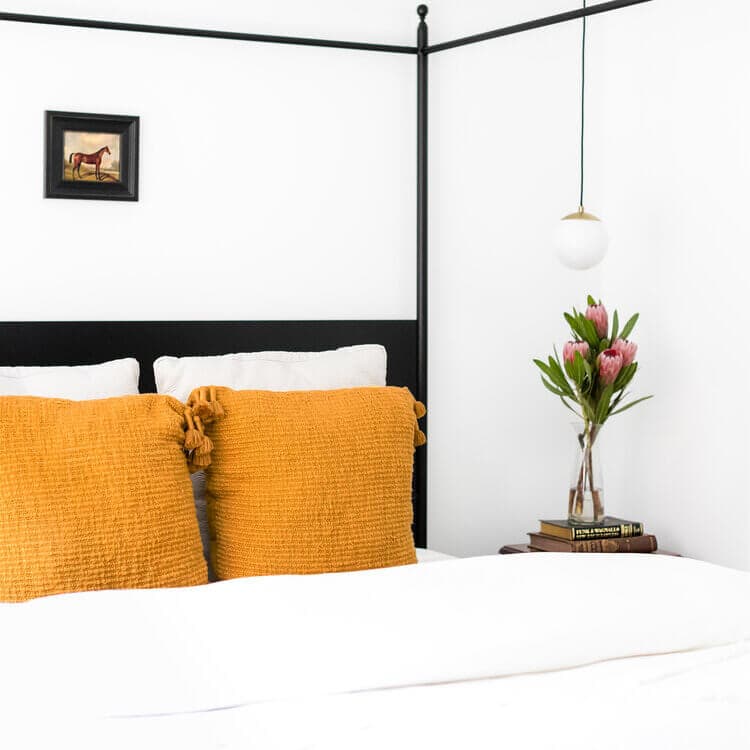 Bedroom with flowers on a nightstand.