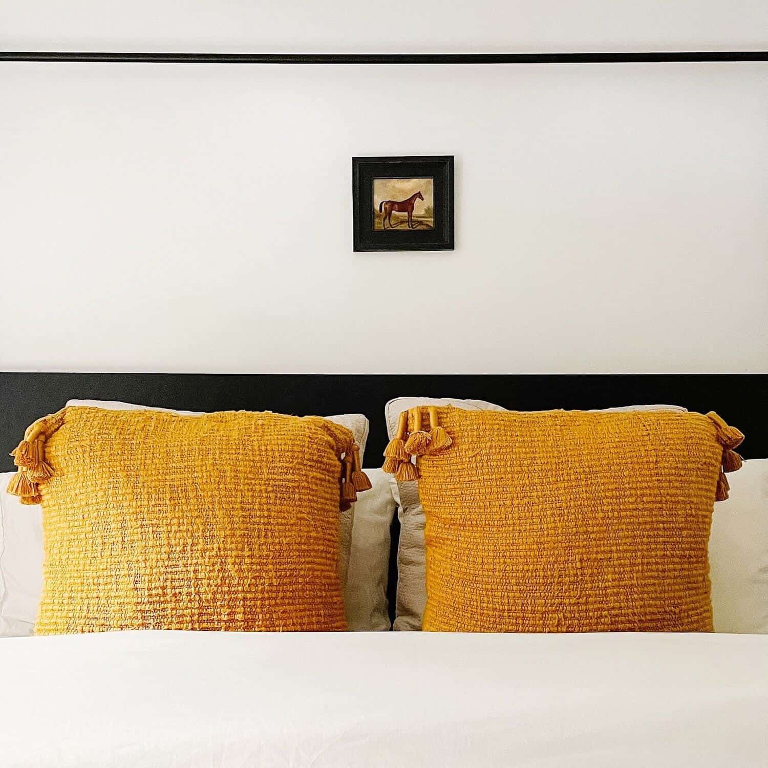 Small picture of a horse hanging above a bed.