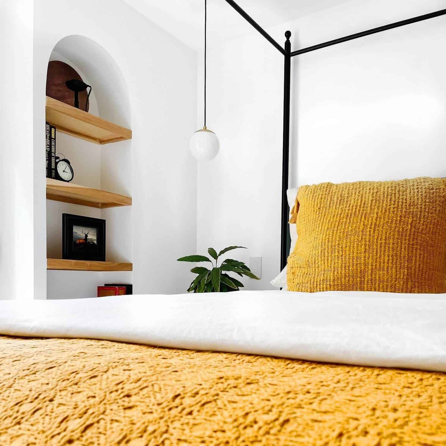 White and golden bedding on a bed.