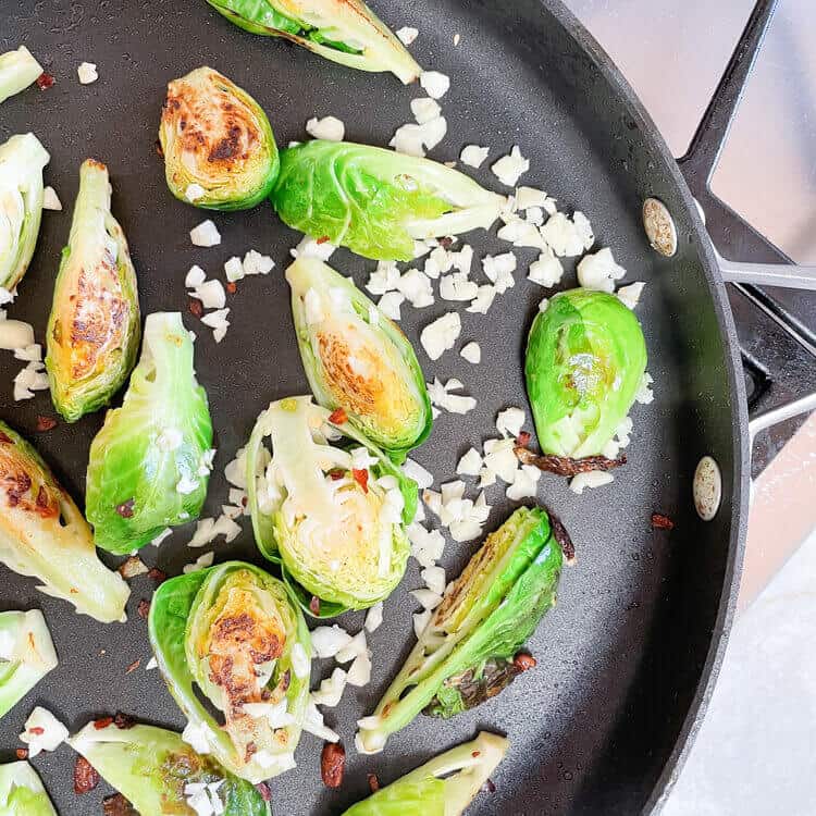 Brussels sprouts cooking in a pan.