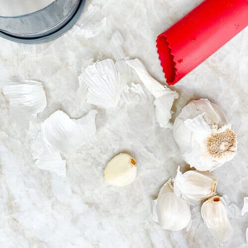 Garlic bulb and cloves with a garlic skin remover.