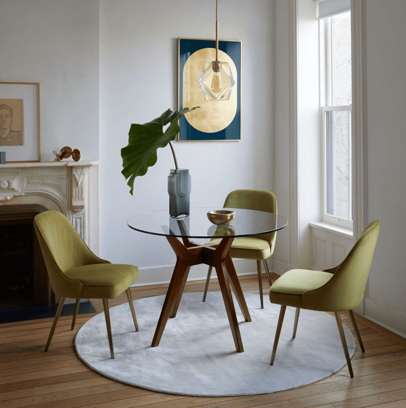 Round table with a glass top and walnut legs.