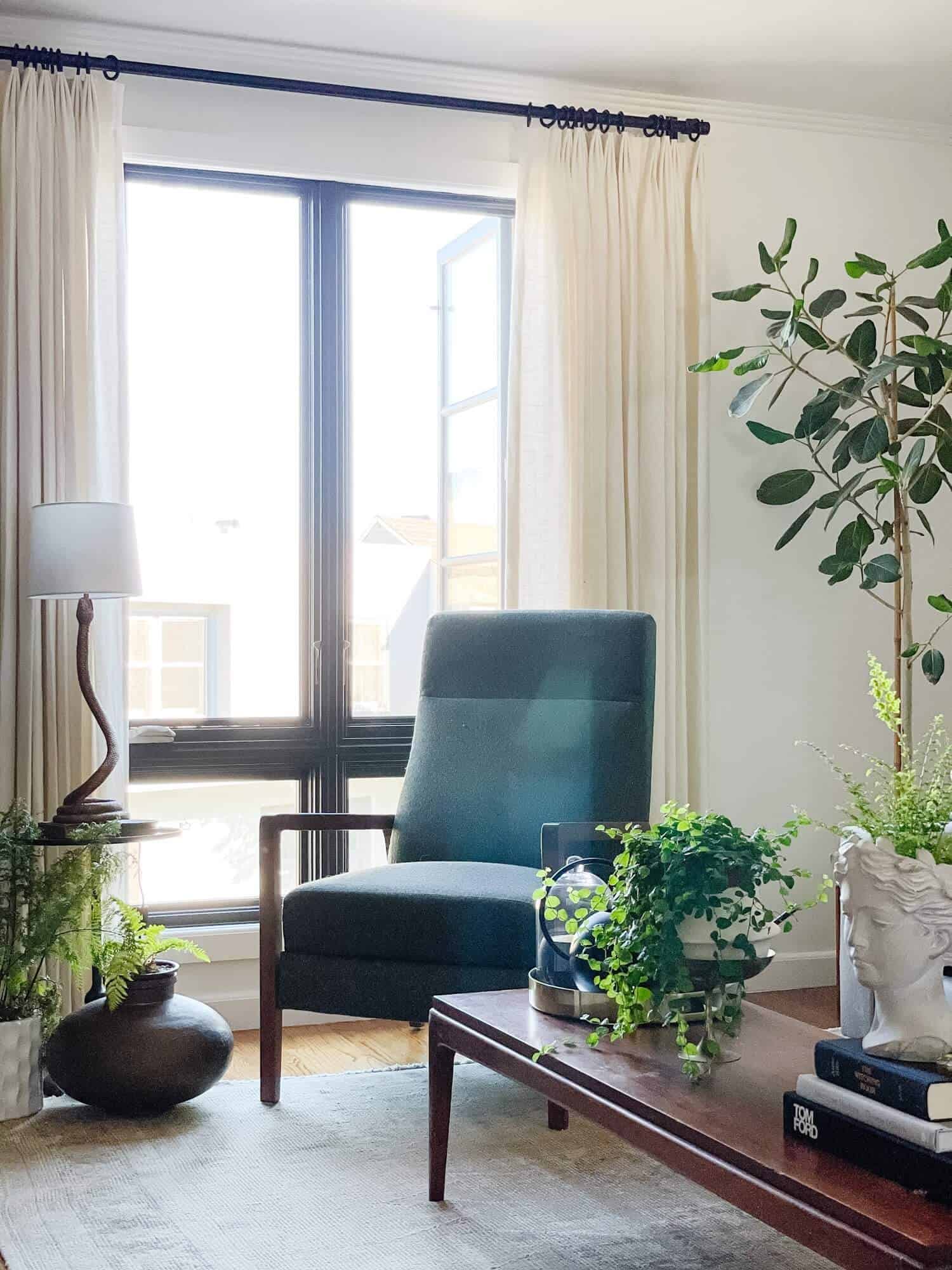 Curtains hanging high over a bright window.