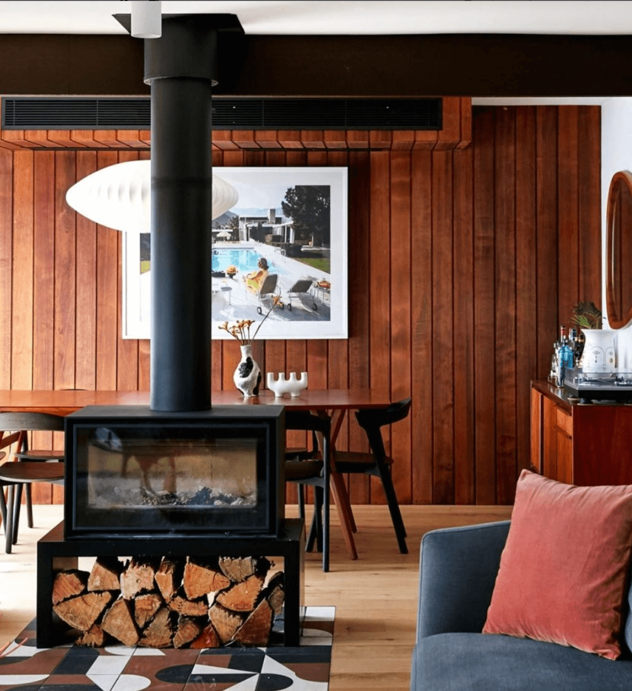 Fireplace in a room with wood paneled walls.