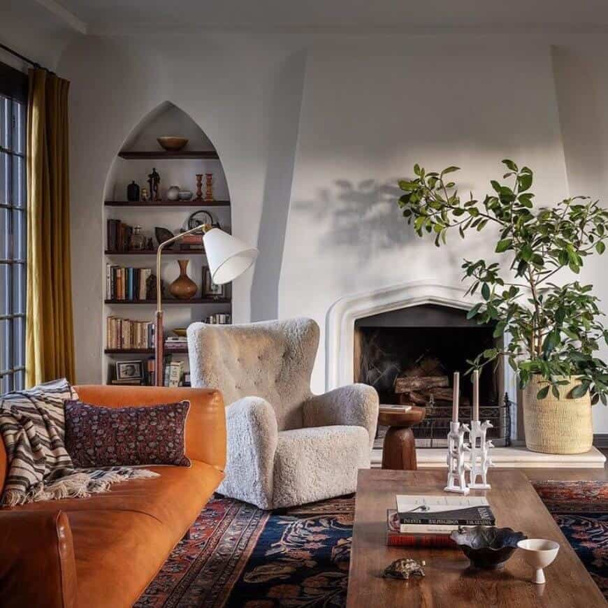 Orange sofa in a room with a white chair and white walls.