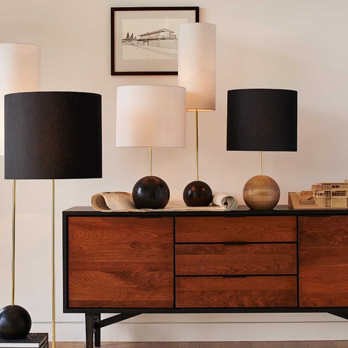 Several drum lamps on and around a dresser.