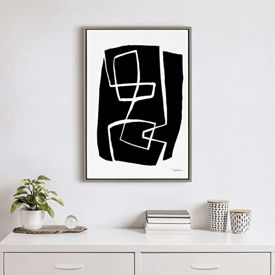 Black and white art on a white wall.