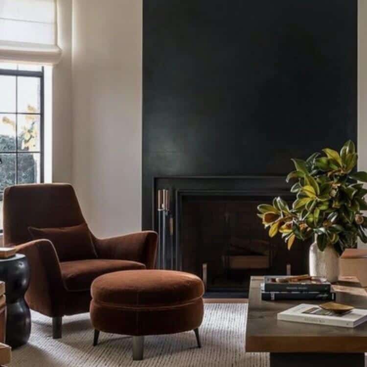 Brown chair in a room with a black accent wall.