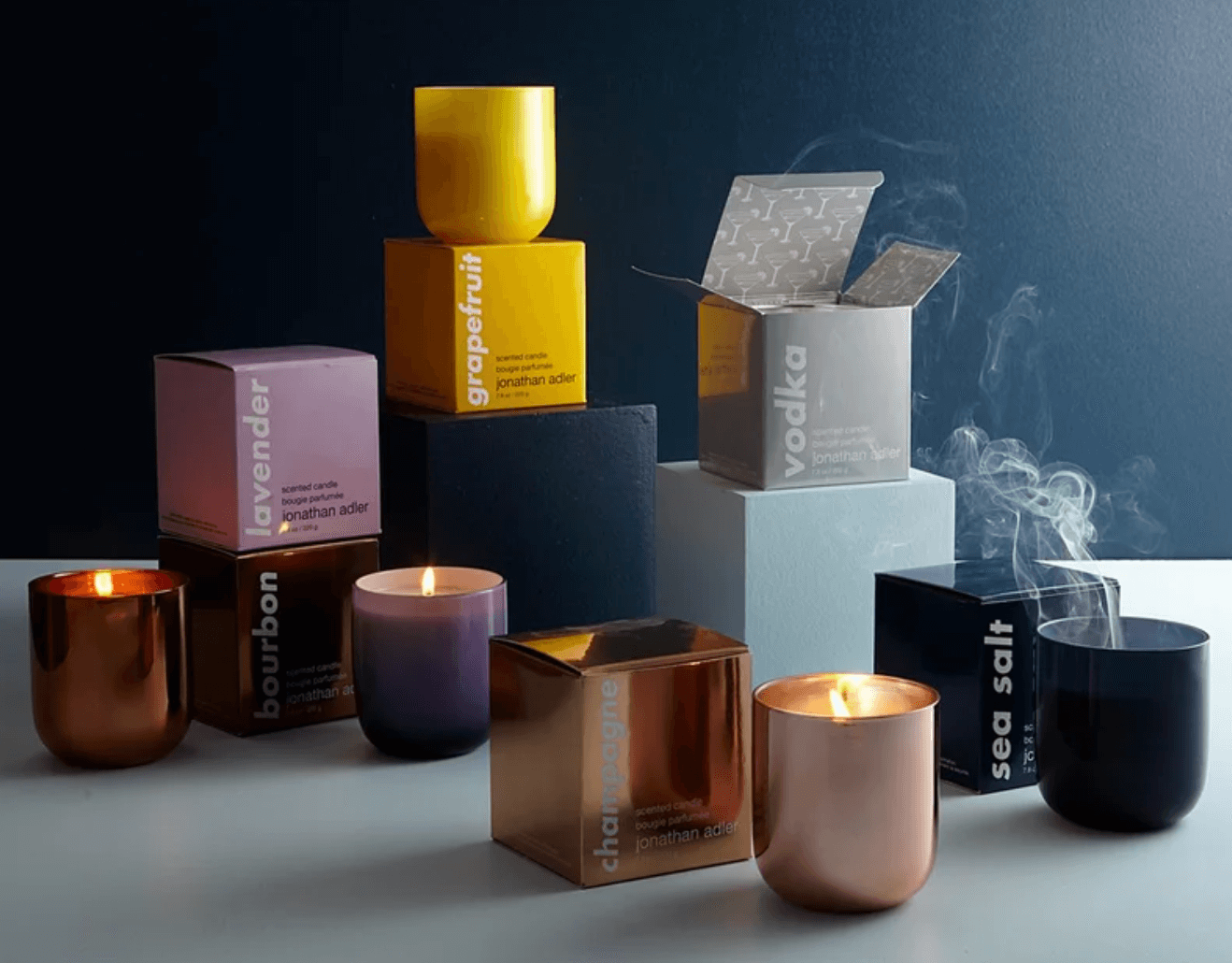 Several boxes and candles with different colors and scents.