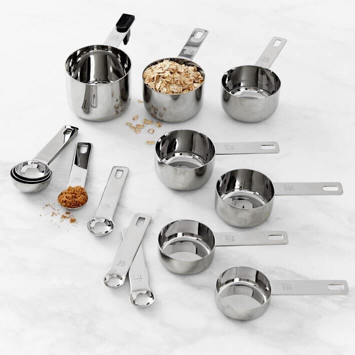 Fourteen metal measuring cups and spoons.