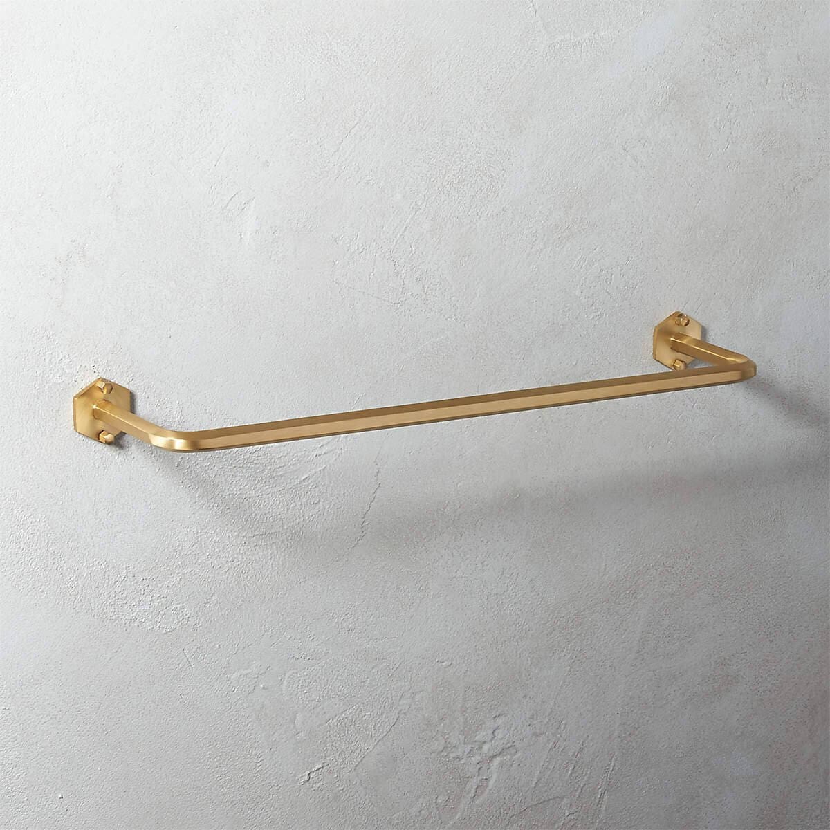 Brushed brass towel bar on a wall.