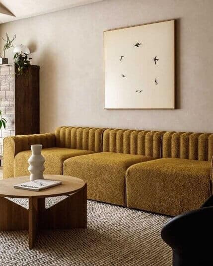 Mustard sofa in a room with minimalist art.