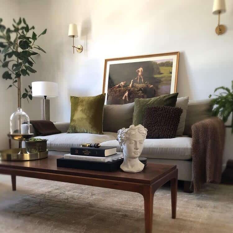 Coffee table in a living room with a sofa and art.