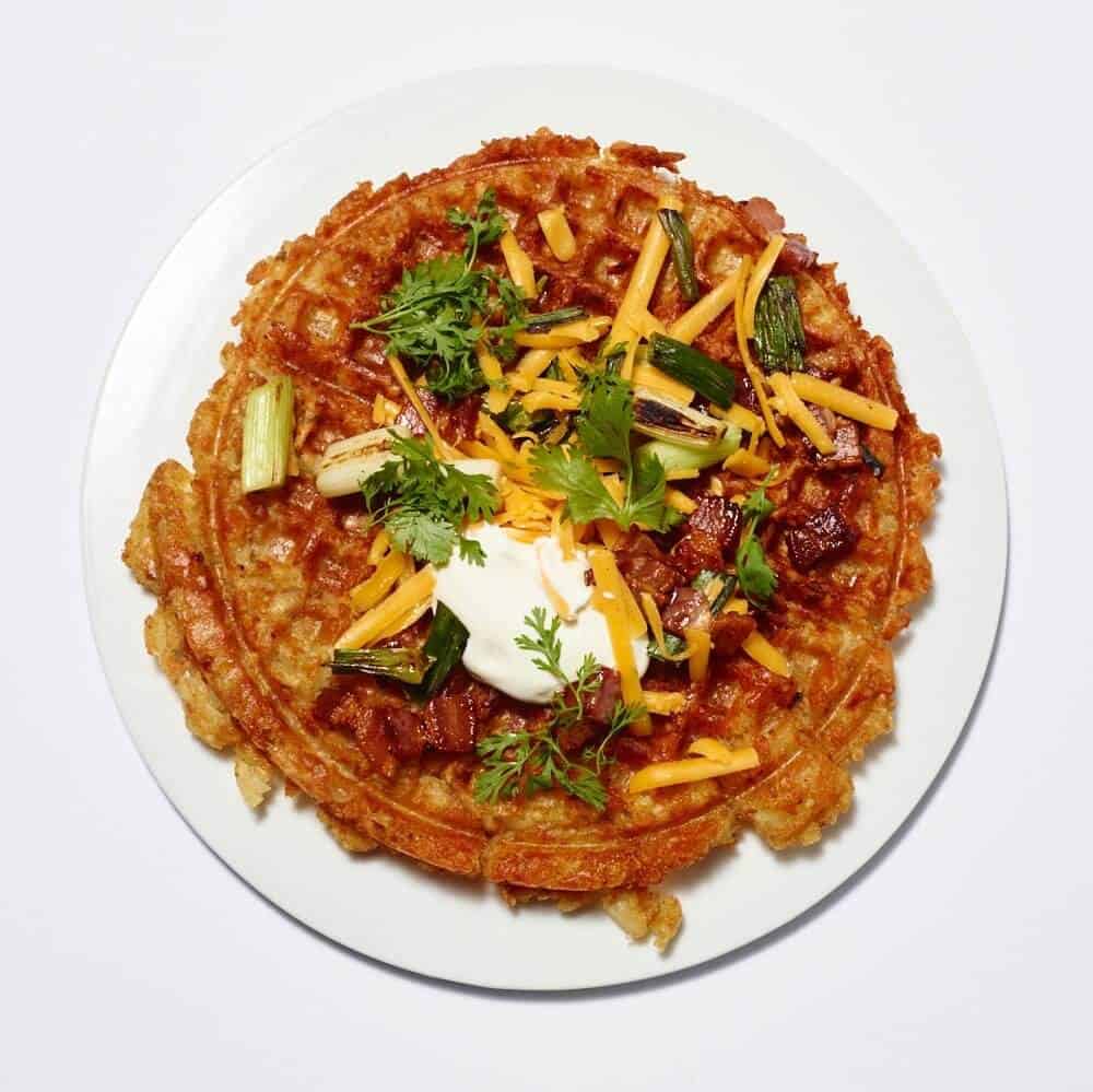 Tater tot bacon waffle on a white plate.