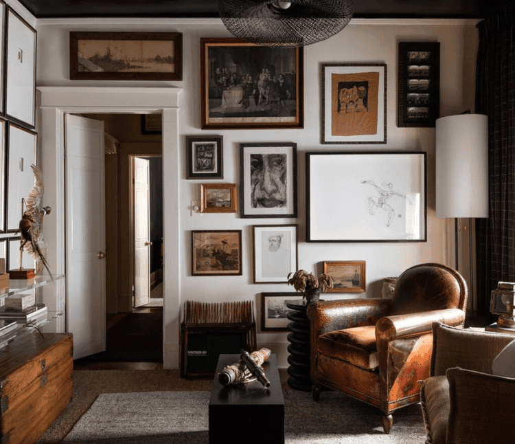 Gallery wall in a room with an armchair.