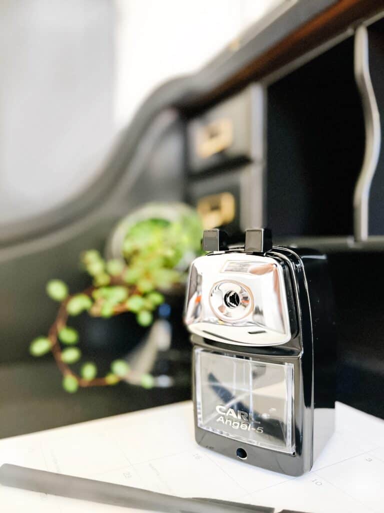Black pencil sharpener on a desk.