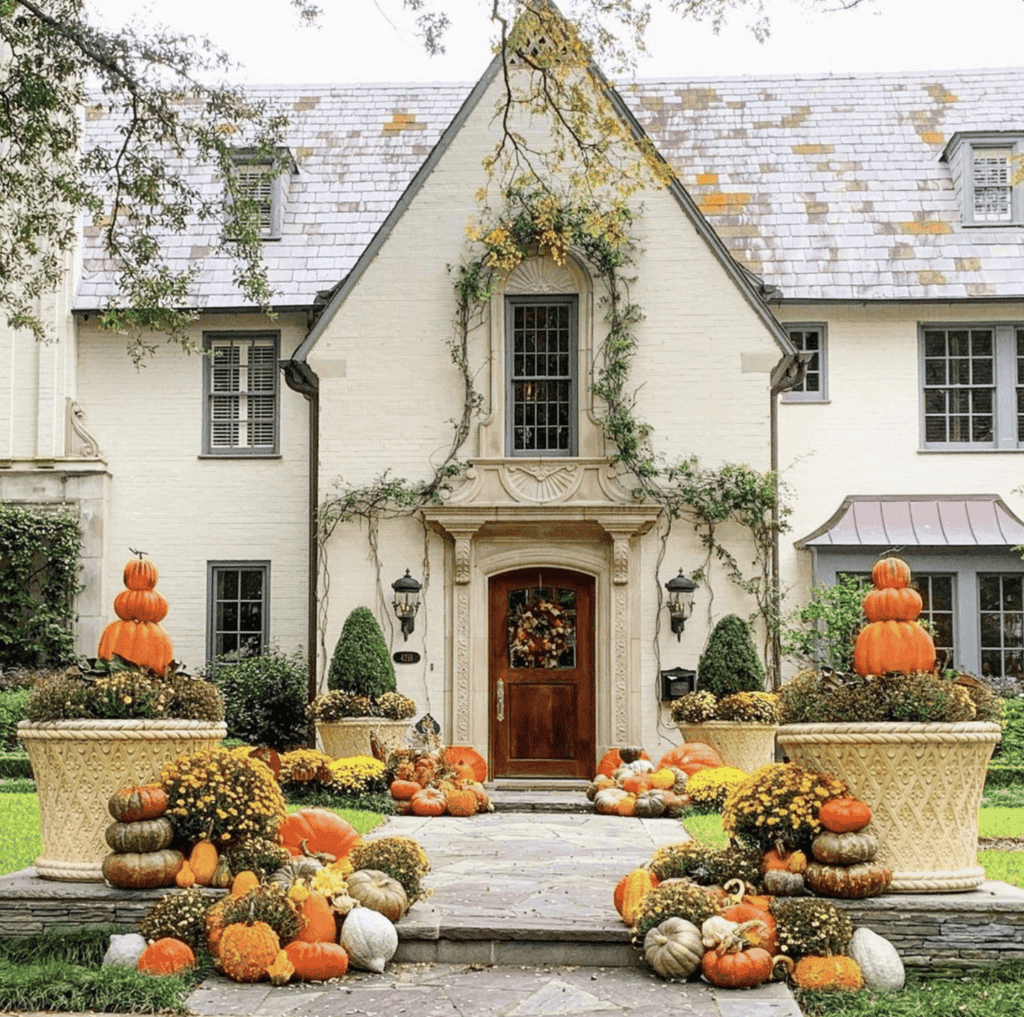 Pumpkins adorning the walkway to a house.