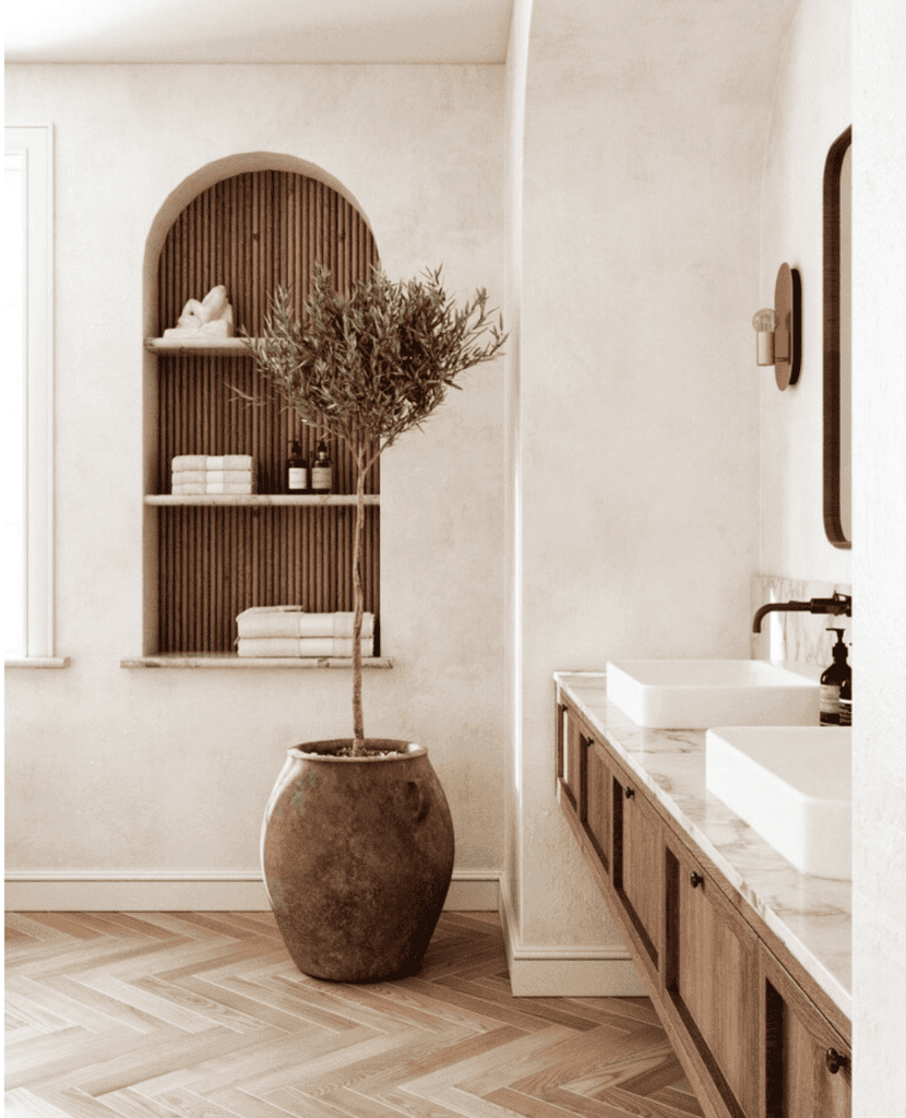 An arched bookcase in a room with a sink and a mirror.