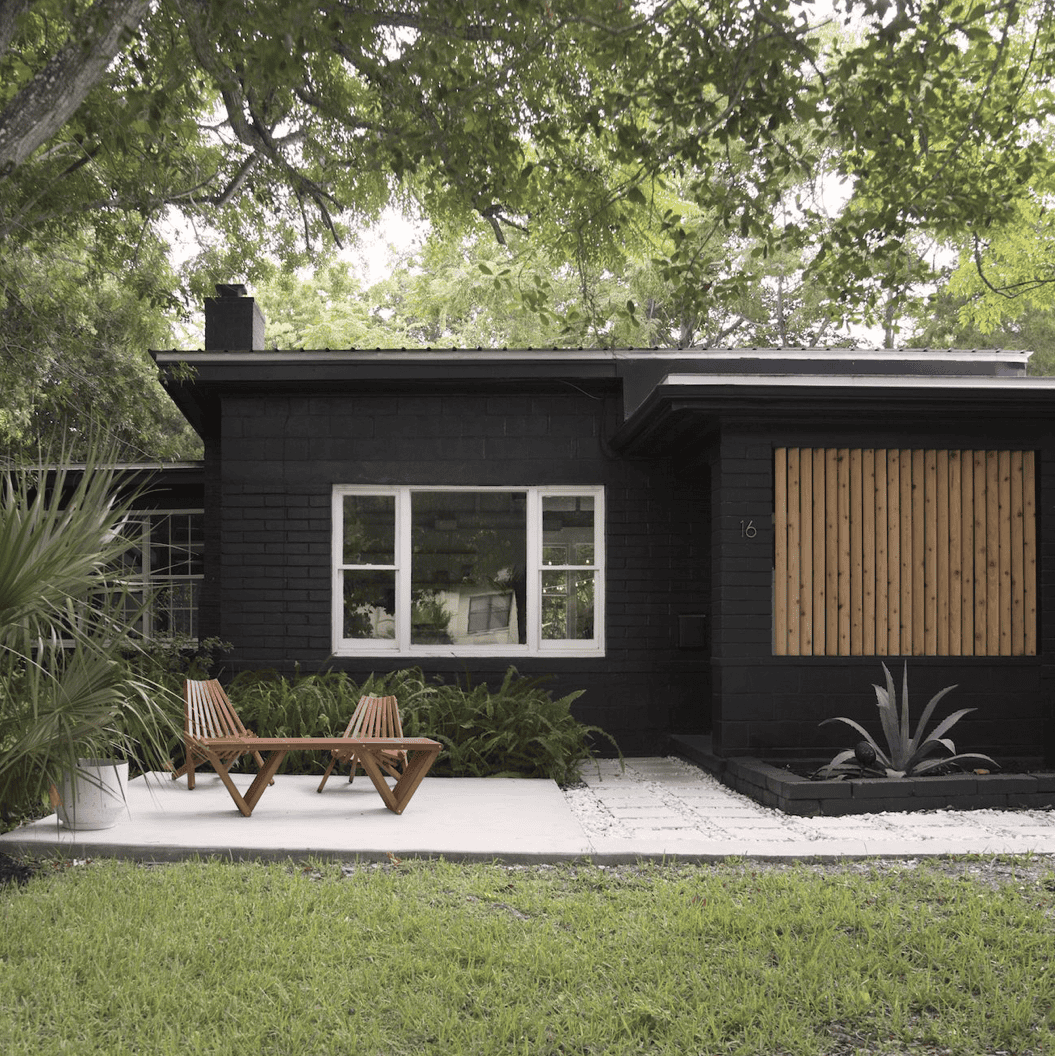 A large lawn in front of a house with sw tricorn black exterior