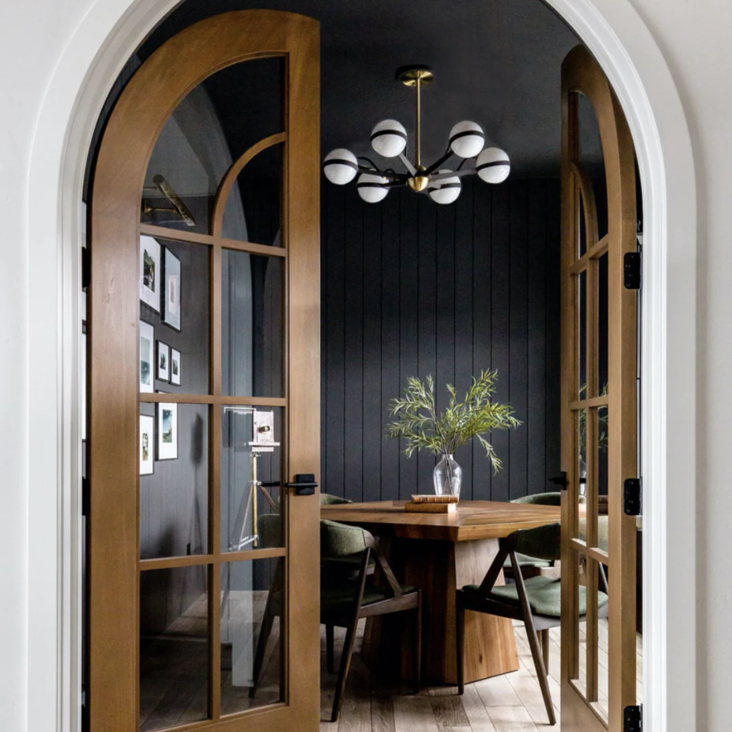 SW tricorn black paint with a dining room table in front of a door and gallery wall