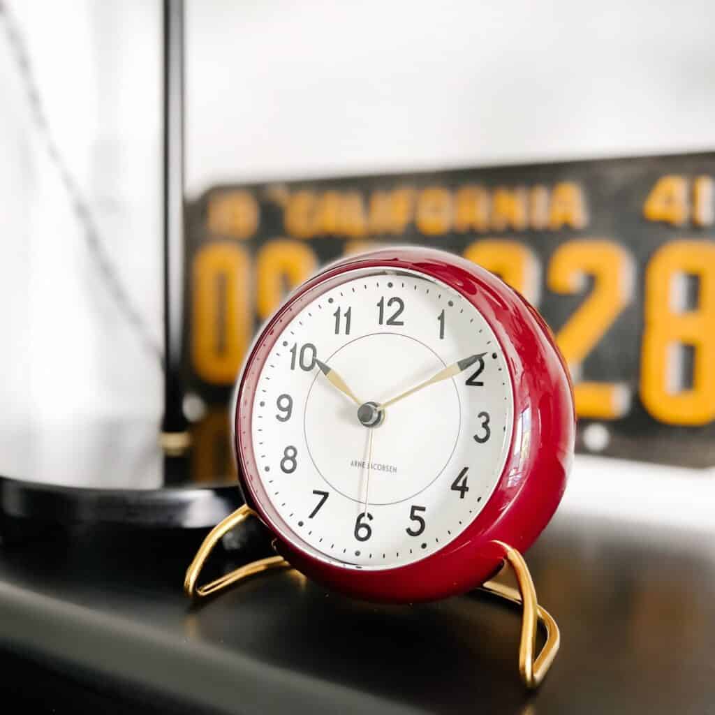 Burgundy clock on a black table.