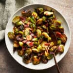 Spoon on a plate with brussels sprouts.