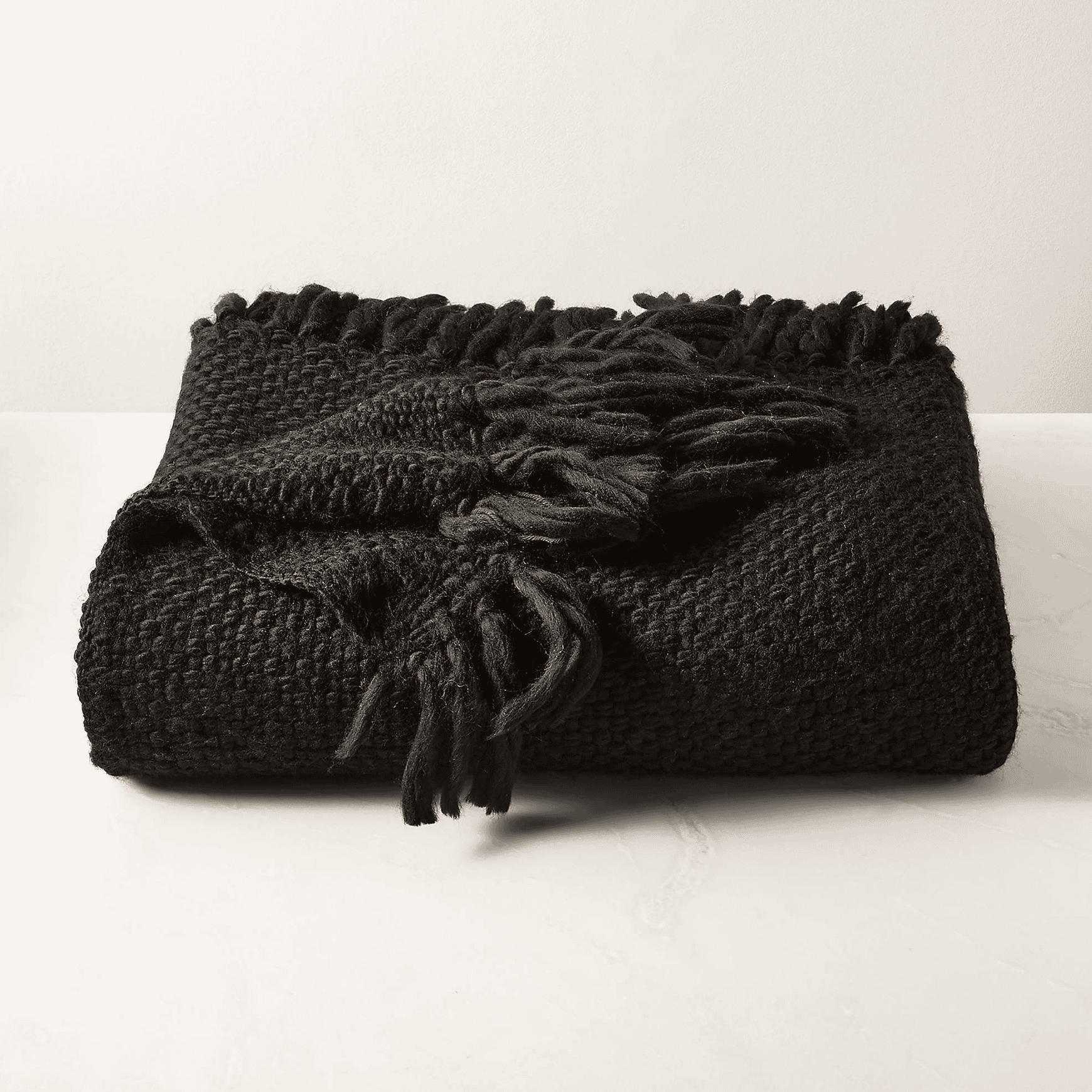 Folded black wool throw blanket.