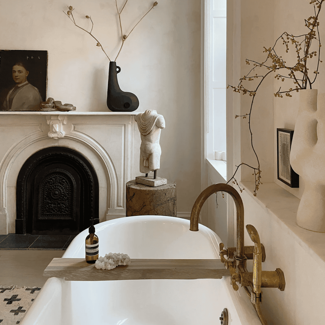 Light-colored bathroom with several art pieces.
