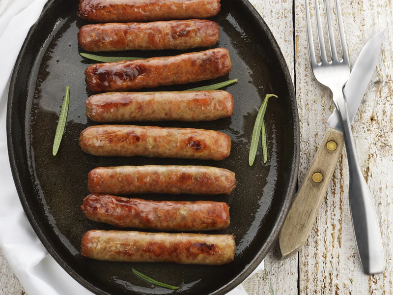 Black plate full of sausage links.