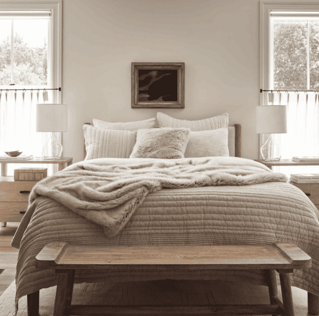 Wooden bed frame with grey linens.