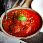 Spoon in a bowl of spaghetti sauce made with fresh tomatoes.