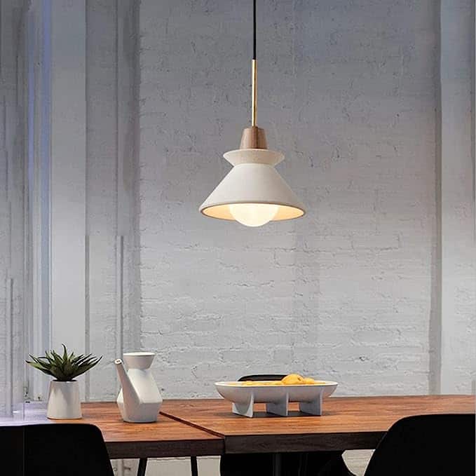 Cement chandelier hanging over a table.