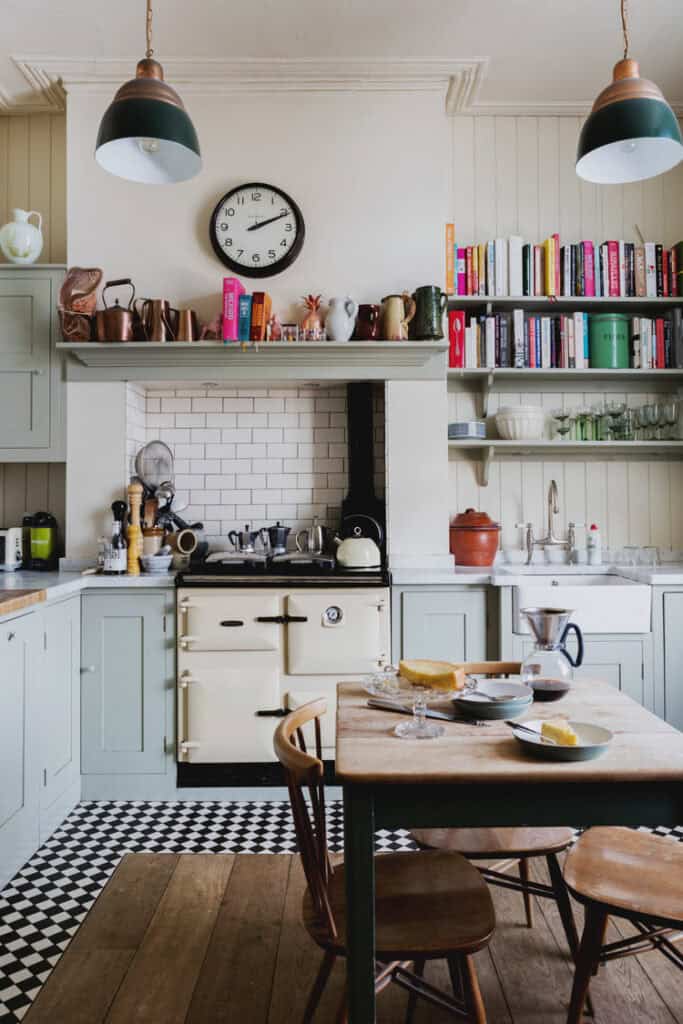 Kitchen with colorful books and small-tiled black and white floor.