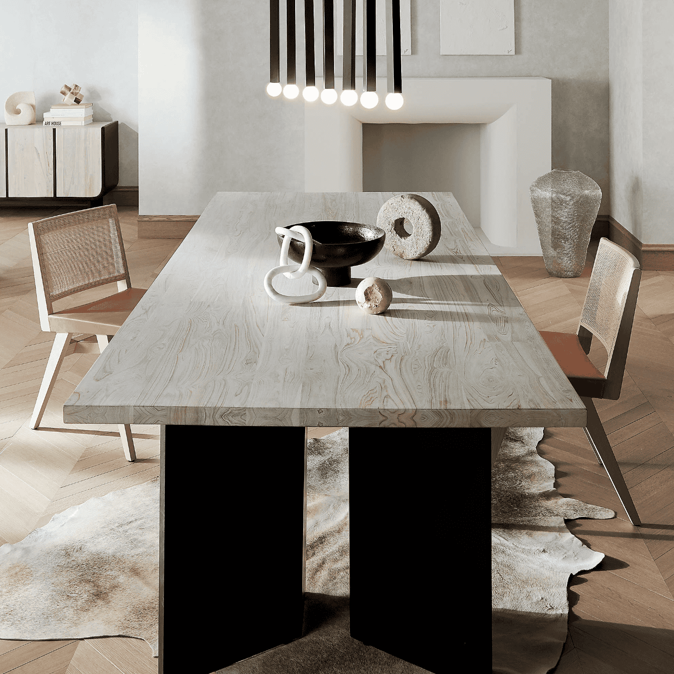 Black ceramic pedestal bowl on a rectangular table.