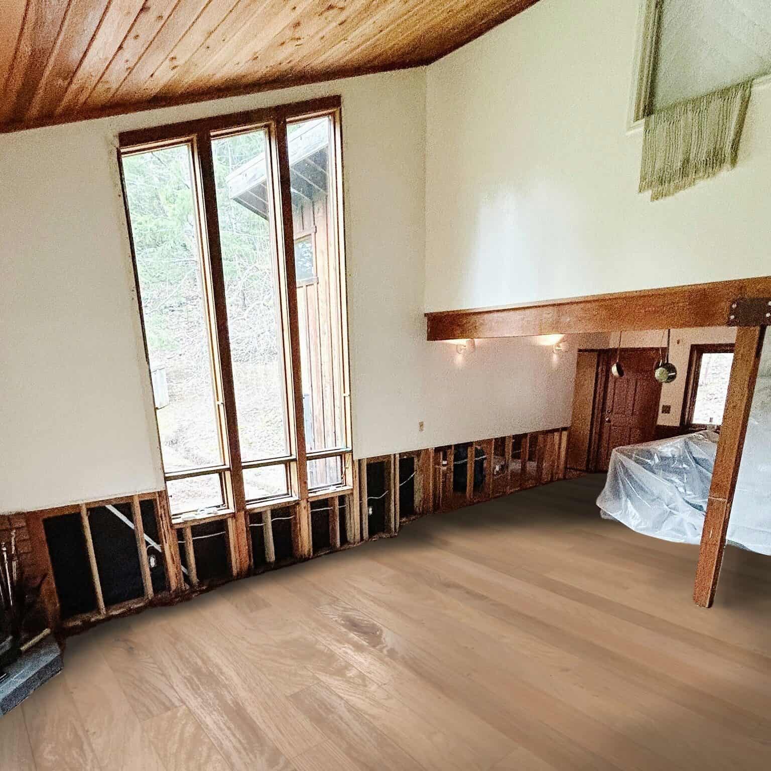 Unfinished room with tall windows and light wood floors.