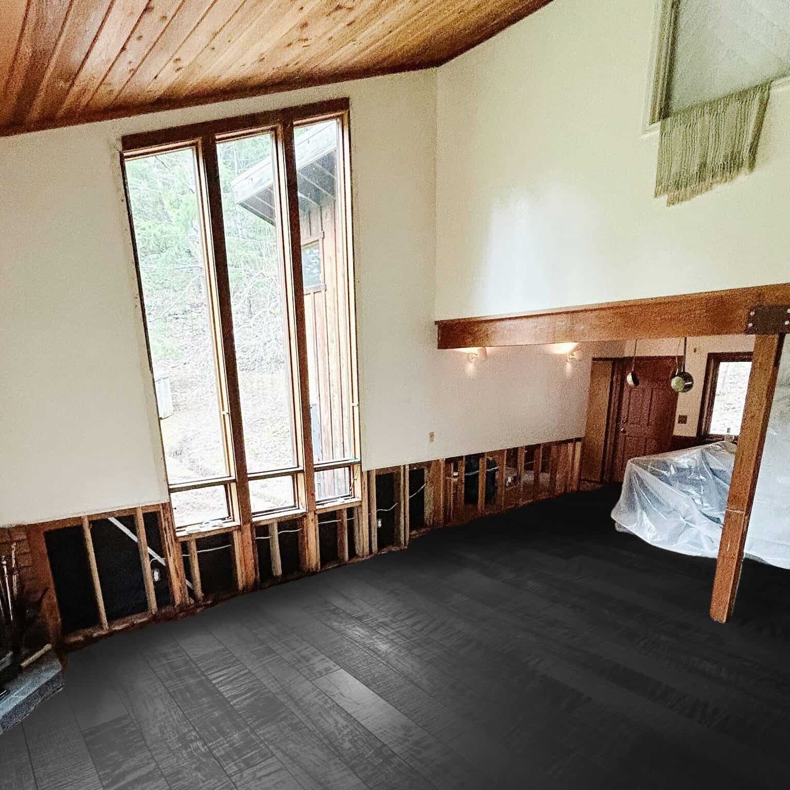 Unfinished room with tall windows and dark floors.