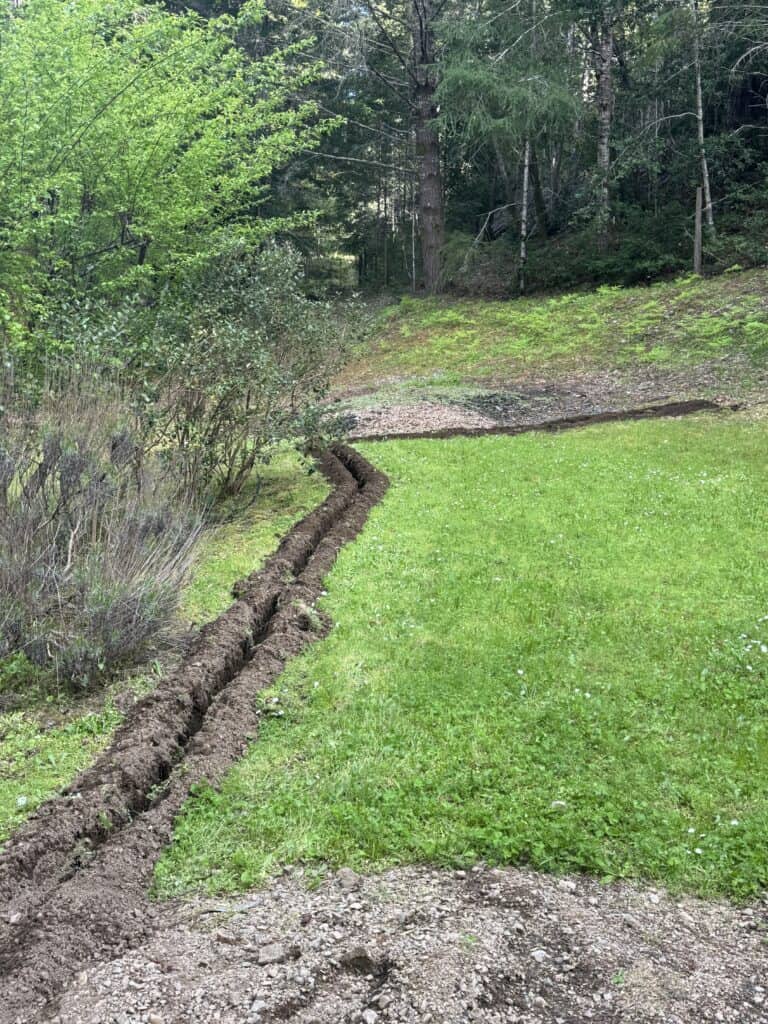 Trench dug into a green lawn.