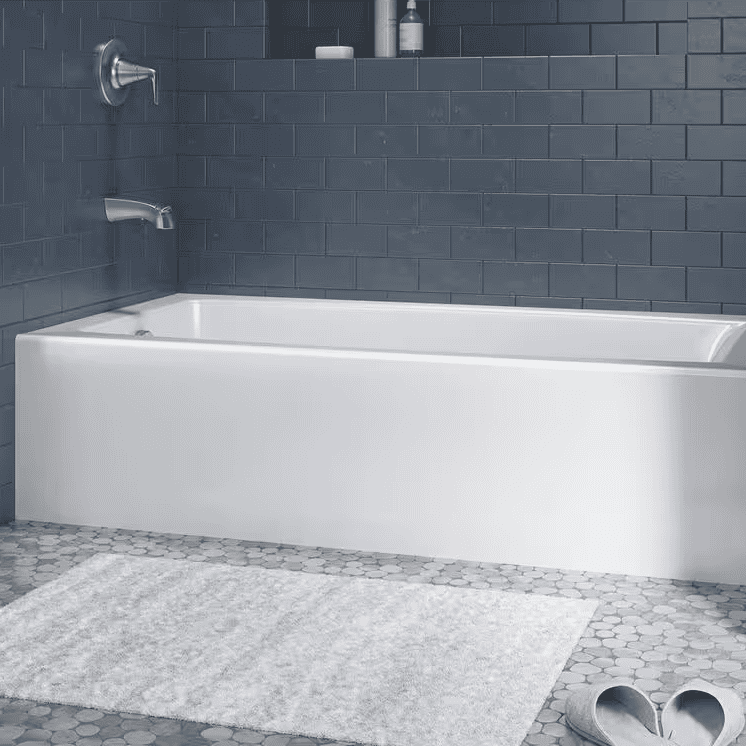 White bathtub surrounded by dark blue tiling.