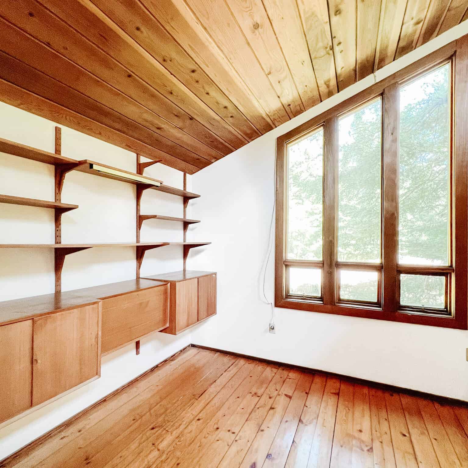Unfurnished room with wood ceiling, floor, and shelves.