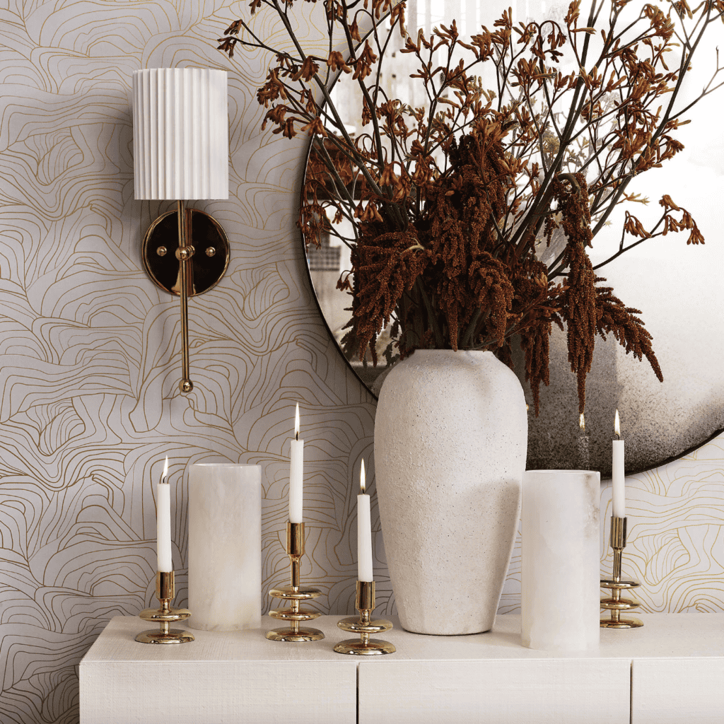Tall, white vase on a table with candles.