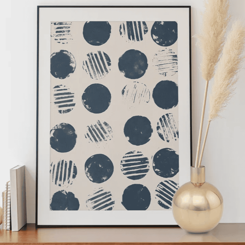 Golden vase on a table with blue and white art.