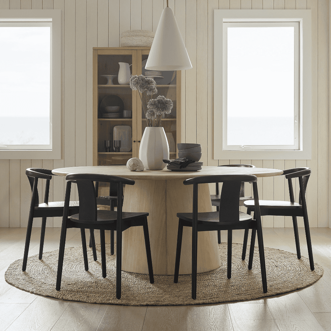 Round jute rug under a round table with chairs.